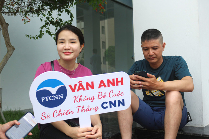Vợ chồng chị Nguyễn Nga làm một tấm biển mang dòng chữ: “Vân Anh – không bỏ cuộc, sẽ chiến thắng CNN” để cổ vũ con gái đi thi. Ảnh: KMC IMG_2215.JPG
