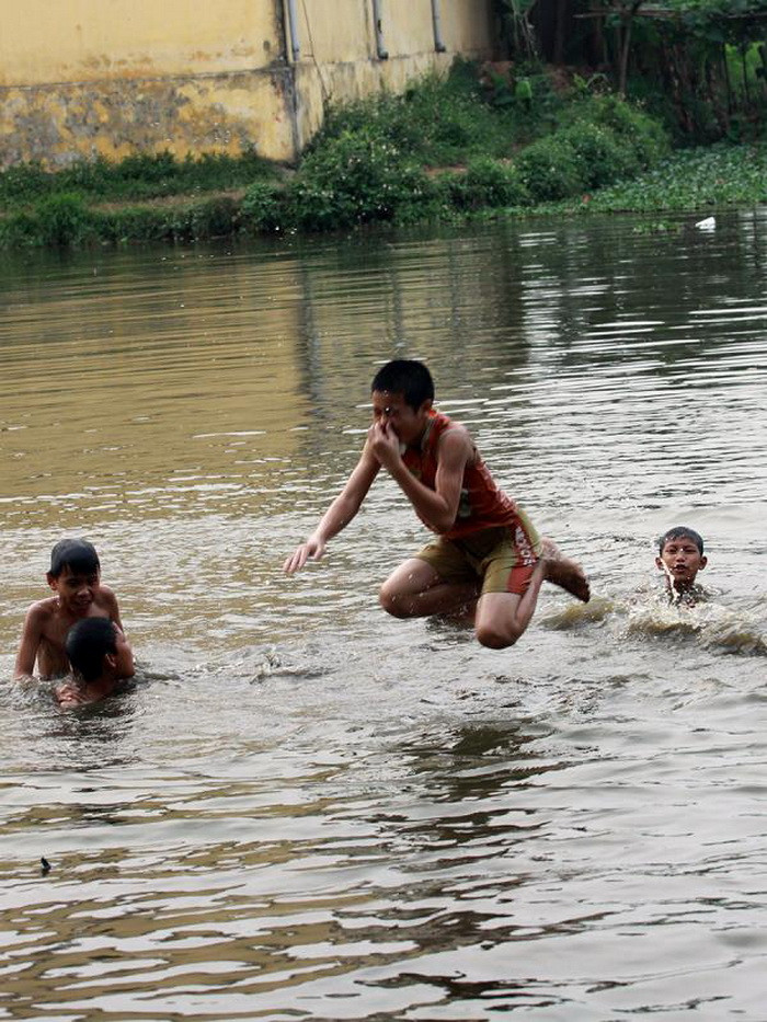 Trong khi ở thành phố được tắm ở bể bơi sạch sẽ, thì những đứa trẻ ở xã Ngọc Mỹ, huyện Quốc Oai chọn ra sông, hồ để giải tỏa nóng bức của mùa hè. Chúng đều ở độ tuổi 10 - 14 tuổi, hồn nhiên cười đùa nghịch ngợm dưới dòng nước mà không hề lo sợ, ngại ngùng khi có người chụp ảnh.