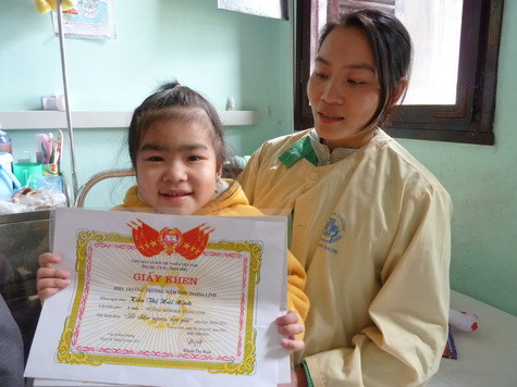 Hải Minh tươi cười khoe giấy khen lớp mẫu giáo 3 tuổi và 4 tuổi. Em rất muốn đi học trở lại, nhưng đã hơn một năm nay việc đó là quá xa vời. Hải Minh là một trong những học sinh nhỏ tuổi và chăm chỉ nhất lớp học Hy vọng Hải Minh tươi cười khoe giấy khen lớp mẫu giáo 3 tuổi và 4 tuổi. Em rất muốn đi học trở lại, nhưng đã hơn một năm nay việc đó là quá xa vời. Hải Minh là một trong những học sinh nhỏ tuổi và chăm chỉ nhất lớp học Hy vọng