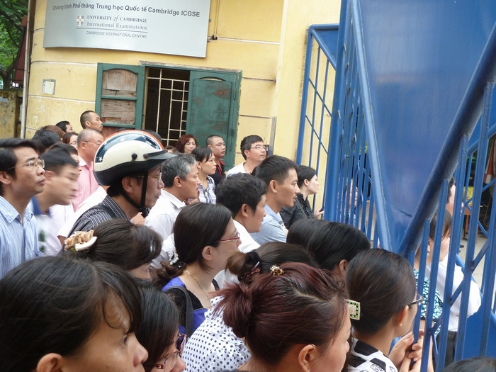 Chăm chú theo dõi con em mình làm thủ tục vào thi. Chăm chú theo dõi con em mình làm thủ tục vào thi.