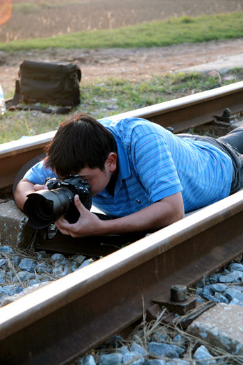 Nằm bò giữa đường ray tàu hỏa để có góc độ đẹp. Ảnh: Mạnh Duy. Nằm bò giữa đường ray tàu hỏa để có góc độ đẹp. Ảnh: Mạnh Duy.