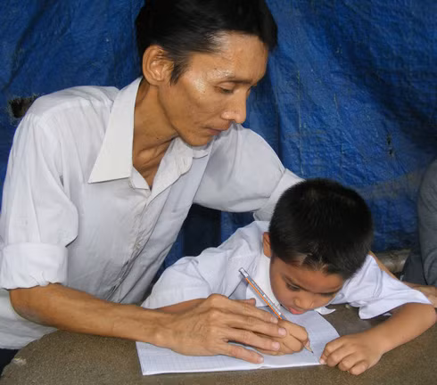 Thầy Hưng tập viết chữ cho cậu học trò nhỏ