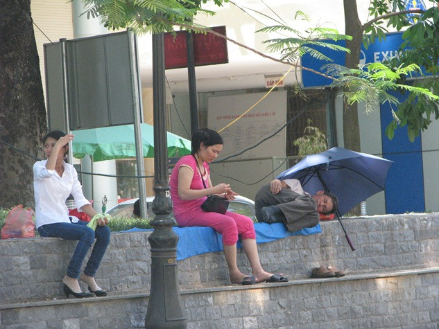 Nhiều người nóng quá không chịu được đành dung ô, dù che tạm giấc ngủ.