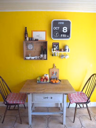Bàn ăn nhỏ ấm cúng với điểm nhấn là tường vàng
