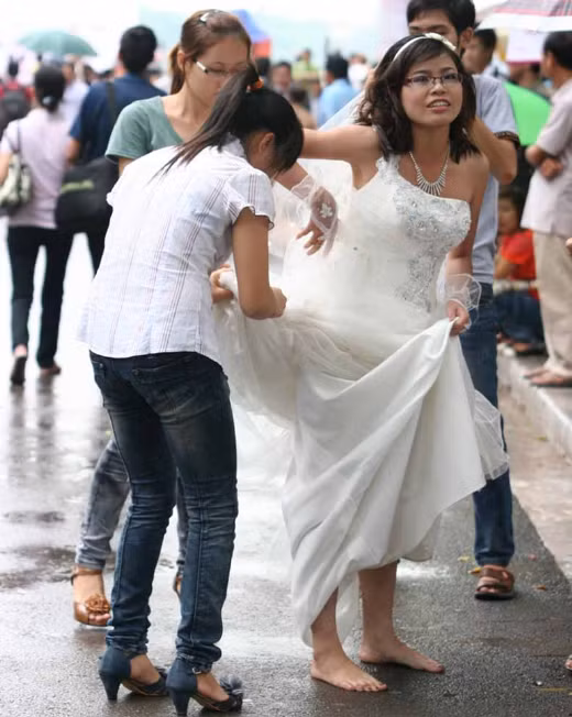 …còn cô dâu thì buộc váy lên cao, bỏ giày cao gót. Ảnh: Sài gòn tiếp thị