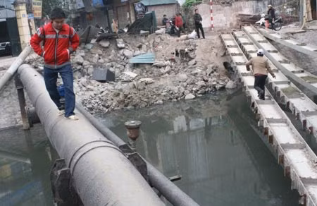 Nhiều người tìm lối đi khác, men theo một đường ống qua sông.