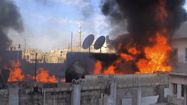Một đám cháy trong thành phố Homs sau khi quân chính phủ Syria nã pháo