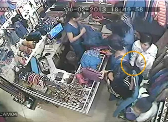 Tên áo đen cầm quần áo che chắn cho áo trắng thò tay móc túi Tên áo đen cầm quần áo che chắn cho áo trắng thò tay móc túi