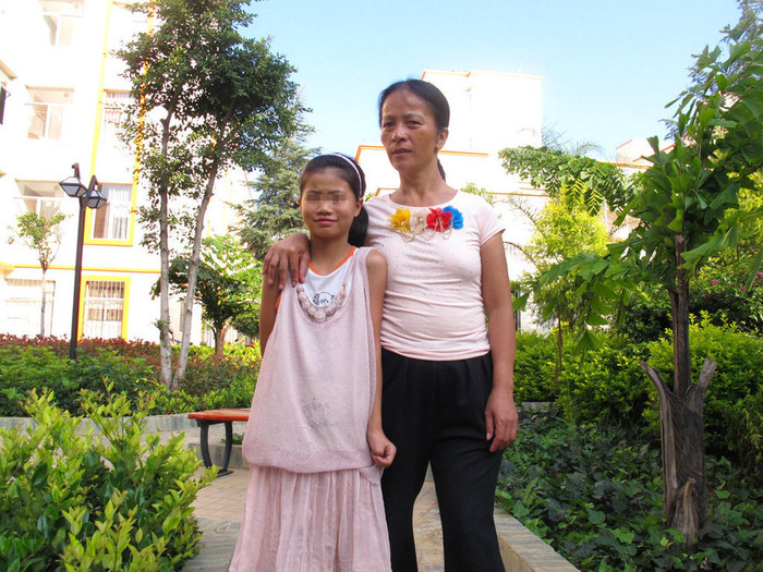 Hai mẹ con trong khuôn viên khu chung cư giá rẻ dành cho người nghèo vừa mới xây dựng Hai mẹ con trong khuôn viên khu chung cư giá rẻ dành cho người nghèo vừa mới xây dựng