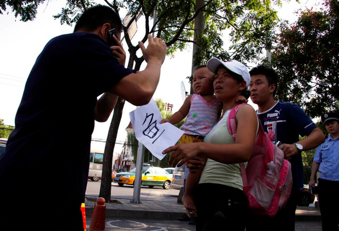 Người phụ nữ bế theo con nhỏ, tay cầm tờ giấy viết chữ "Ngư" ám chỉ đảo Điếu Ngư/Senkaku là của Trung Quốc và phản đối Nhật Bản tuyên bố chủ quyền đối với nhóm đảo này Người phụ nữ bế theo con nhỏ, tay cầm tờ giấy viết chữ "Ngư" ám chỉ đảo Điếu Ngư/Senkaku là của Trung Quốc và phản đối Nhật Bản tuyên bố chủ quyền đối với nhóm đảo này