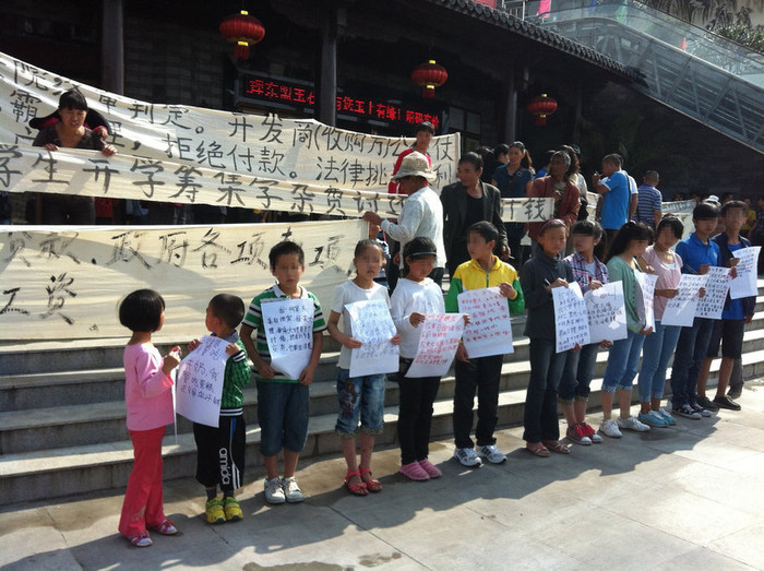 Đứa nhỏ nhất mới có 5 tuổi cầm tờ biểu ngữ viết tay nghuệch ngoạc: "Cháu cần uống sữa! Hãy trả tiền bố mẹ cháu!" Đứa nhỏ nhất mới có 5 tuổi cầm tờ biểu ngữ viết tay nghuệch ngoạc: "Cháu cần uống sữa! Hãy trả tiền bố mẹ cháu!"