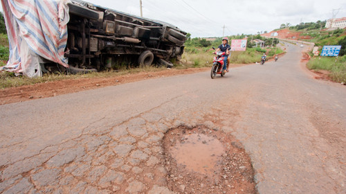 Sau khi thu phí bảo trì đường bộ, Bộ GTVT có bảo đảm sẽ không còn những ổ voi như thế này? Trong ảnh: một xe tải bị lật do tránh ổ voi ở quốc lộ 14, đoạn qua huyện Đắk Mil, tỉnh Đắk Nông. Ảnh: Tiến Thành