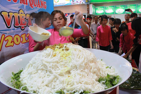 Để tạo ra mùi vị đặc trưng của mì Quảng, các đầu bếp phải chế biến rất tỉ mỉ, cách tẩm gia vị cũng phải đặc biệt. Chỉ riêng cách rim gà, chị Hồng và 4 phụ bếp phải tiến hành liên tục trong vòng 2 tiếng đồng hồ bằng bếp than dân giã (không dùng bếp gas vì sợ mất mùi)... mới hoàn thành. Ảnh: Tiếp đến cho thịt gà rim và nước chan Để tạo ra mùi vị đặc trưng của mì Quảng, các đầu bếp phải chế biến rất tỉ mỉ, cách tẩm gia vị cũng phải đặc biệt. Chỉ riêng cách rim gà, chị Hồng và 4 phụ bếp phải tiến hành liên tục trong vòng 2 tiếng đồng hồ bằng bếp than dân giã (không dùng bếp gas vì sợ mất mùi)... mới hoàn thành. Ảnh: Tiếp đến cho thịt gà rim và nước chan