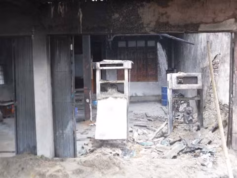 Vụ cháy làm hai trụ bơm xăng bị thiêu rụi hoàn toàn. Vị trí mái che trụ bơm xăng và tường nhà cũng bị hư hỏng nặng. Ảnh: Long Nhi