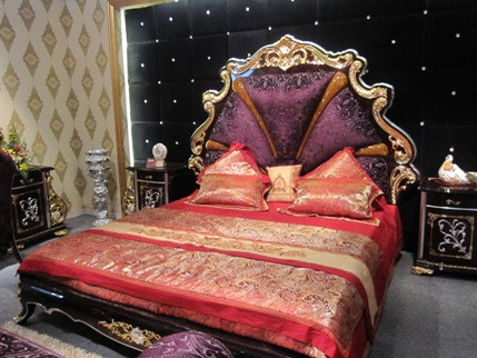 Chị Nguyễn Ngọc Bích (Nhân viên bán hàng thương hiệu Ricco Lux) cho biết: “Những bộ sản phẩm trên 1 tỷ đồng có khung xương làm bằng gỗ óc chó châu Phi, mặt bàn sử dụng vân công nghiệp. Còn các họa tiết trên tất cả các sản phẩm đều được dát vàng 24k. Trên sản phẩm dùng loại gấm tím. Các sản phẩm này đắt là do được dát vàng”. Ảnh: Bộ giường ngủ VIP gồm giường, bàn trang điểm, tủ, kệ 2 đầu giường có giá 1,1 tỷ đồng