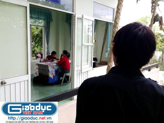 Chồng bà Lê Thị Tuyết, ông Lê Đình Phú đứng từ xa nhìn người vợ có máu "hoạn Thư", bà Lê Thị Tuyết, trước giờ bà bị công an thành phố Thủ Dầu Một, tỉnh Bình Dương tống đạt lệnh bắt giam. Ảnh: Dương Cầm