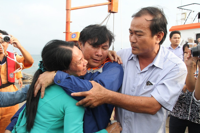 Thuyền trưởng tàu cá QNa 95959 TS Phạm Phú Thành trong vòng tay người thân khi trở về đất liền an toàn. Ảnh Hoàng Tuấn