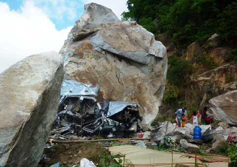 Chiếc ôtô bị hòn đá to đè bẹp nát. Ảnh: Đ.X.