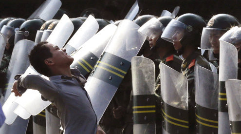 Một kẻ biểu tình quá khích đang ra sức ném trứng về phía Đại sứ quán Nhật Bản