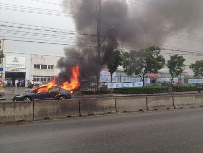 Biểu ngữ chống Nhật Bản giăng khắp nơi, ngay cả trước địa điểm đốt xe để gây sự chú ý với dư luận