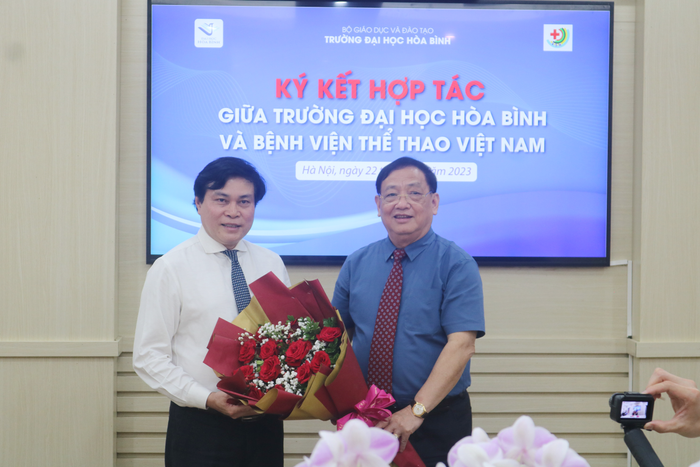 Hiệu trưởng Trường Đại học Hòa Bình tặng hoa Giám đốc Bệnh viện Thể thao Việt Nam. Ảnh: DN Hiệu trưởng Trường Đại học Hòa Bình tặng hoa Giám đốc Bệnh viện Thể thao Việt Nam. Ảnh: DN