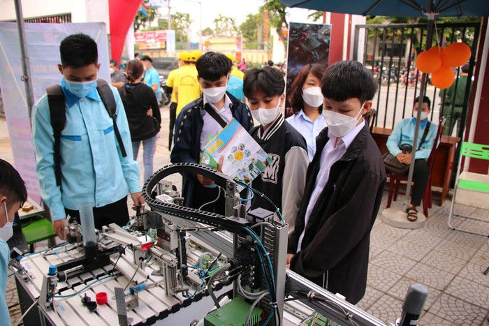 Học sinh trải nghiệm thực tế trên mô hình sản xuất bóng đèn tự động. Hình ảnh tại gian hàng của Trường Cao đẳng nghề Đà Nẵng trong Ngày hội việc làm và tuyển sinh giáo dục nghề nghiệp tại Quận Cẩm Lệ năm 2022. Ảnh: Fanpage nhà trường