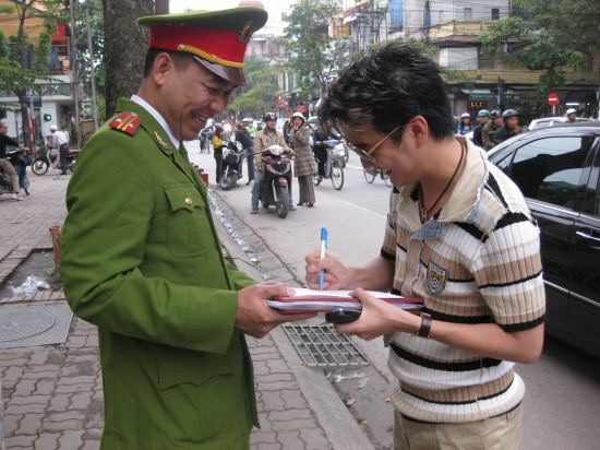 Có vẻ như Mr Đàm viết thêm điều gì đó khiến anh công an vui cười tít mắt... Có vẻ như Mr Đàm viết thêm điều gì đó khiến anh công an vui cười tít mắt...