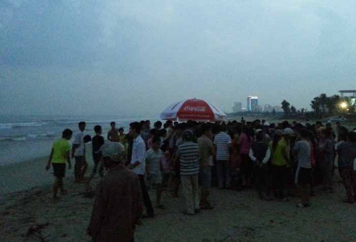 Rất nhiều người hiếu kỳ đứng trên bãi biển theo giõi vụ việc. Ảnh Hoàng Quân