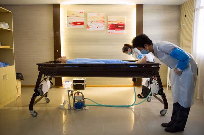 Cúi đầu hành lễ trước khi làm thủ "tắm rửa", trang điểm cho người quá cố là nội dung bắt buộc thể hiện sự kính trọng của nhân viên khâm liệm đối với người quá cố