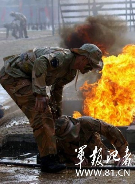 Tập cơ động bò trườn dưới mặt đất bùn trộn đá dăm, vòi rồng xối nước