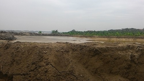 ...bên cạnh là các hố chứa cát được hút trực tiếp từ lòng sông Hồng lên. Ảnh: Phản Thiên ...bên cạnh là các hố chứa cát được hút trực tiếp từ lòng sông Hồng lên. Ảnh: Phản Thiên