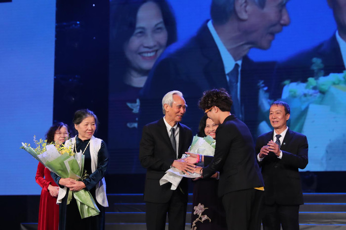 Cựu học sinh tặng hoa thầy Nguyễn Phú Cường - Hiệu trưởng nhà trường từ năm 1990-1998. Ảnh: Nhà trường cung cấp