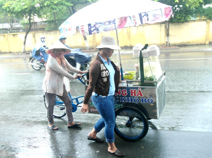 Cuộc mưu sinh vẫn tiếp diễn dưới cơn mưa...