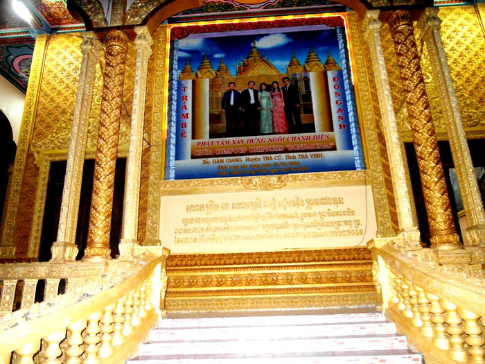 Hình ảnh gia đình ông Trầm Bê treo ngay cổng phụ phía sau ngôi chánh điện chùa Vàm Ray. Ảnh: Dương Cầm Hình ảnh gia đình ông Trầm Bê treo ngay cổng phụ phía sau ngôi chánh điện chùa Vàm Ray. Ảnh: Dương Cầm