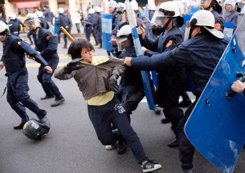 Cảnh sát cơ động Đài Loan được trang bị dùi cui, khiên để giải tán đám đông.