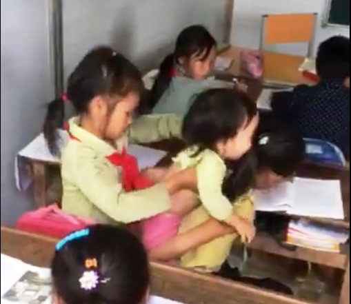 Để có thể đi học, Vàng Thị Hóa phải đưa cả em đến lớp. (Ảnh cắt từ clip) Để có thể đi học, Vàng Thị Hóa phải đưa cả em đến lớp. (Ảnh cắt từ clip)