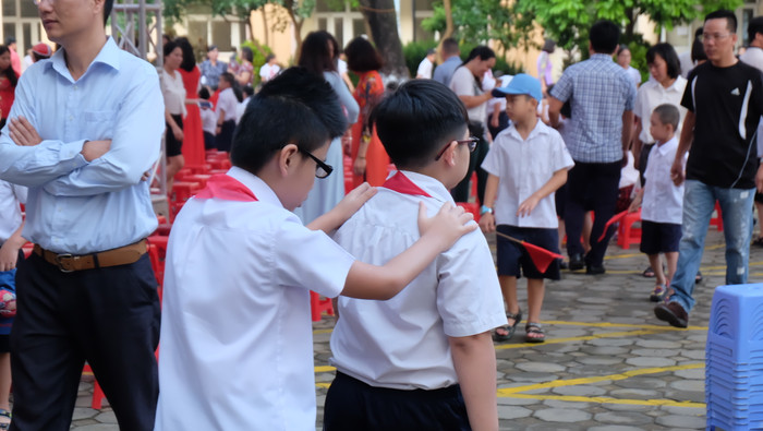 Giúp đỡ bạn vào hàng ghế chuẩn bị chờ lễ khai giảng chuẩn bị bắt đầu.