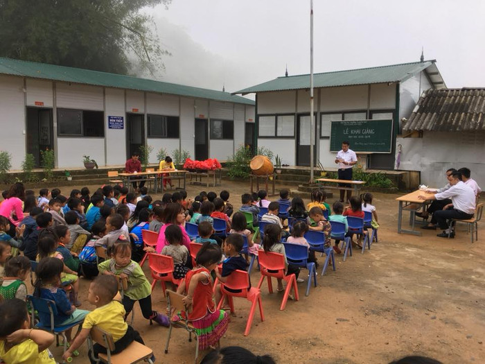 Lễ khai giảng được tổ chức ở điểm trường, có không ít học sinh phải địu theo đi khai giảng. Em ngồi ghế, còn chị ngồi đất. Lễ khai giảng được tổ chức ở điểm trường, có không ít học sinh phải địu theo đi khai giảng. Em ngồi ghế, còn chị ngồi đất.