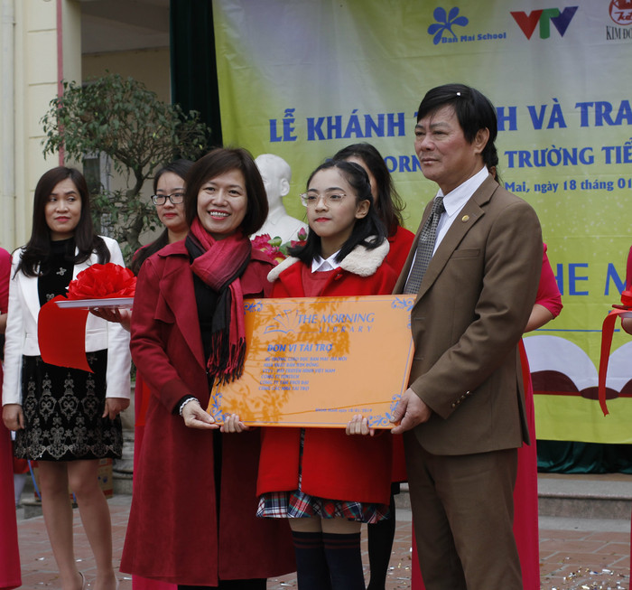 Cô Mai Thị Lan Anh trao biển thư viện The Morning V cho thầy Nguyễn Đình Cư - Hiệu trưởng trường Tiểu học Đồng Mai II. Ảnh: Đ.T
