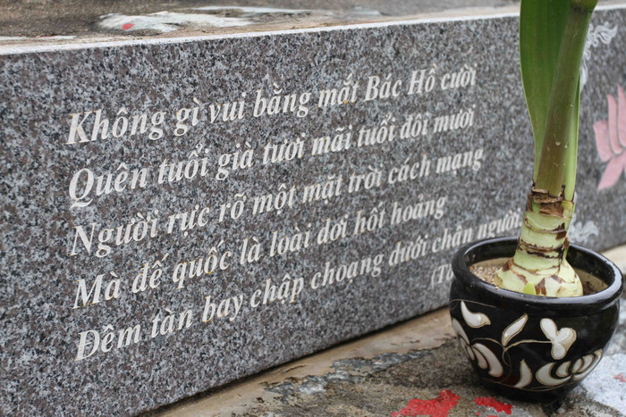 Phía dưới có ghi mấy câu thơ của Nhà thơ Tố Hữu: "Không gì vui bằng mắt Bác Hồ cười. Quên tuổi già tươi mãi tuổi đôi mươi. Người rực rỡ một mặt trời cách mạng. Mà đế quốc là loài dơi hốt hoảng. Đêm tàn bay chập choạng dưới chân người...". Phía dưới có ghi mấy câu thơ của Nhà thơ Tố Hữu: "Không gì vui bằng mắt Bác Hồ cười. Quên tuổi già tươi mãi tuổi đôi mươi. Người rực rỡ một mặt trời cách mạng. Mà đế quốc là loài dơi hốt hoảng. Đêm tàn bay chập choạng dưới chân người...".