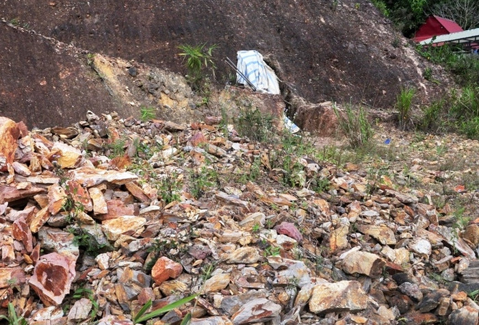 Đất đá lấy từ hầm ra hiện vẫn còn y cả đống ngay miệng hầm gần đường cái trục chính của tuyến đường số 01 đi biên giới, đất đá này hiện nay úa màu, rêu mốc. Ảnh Hoàng Tuấn