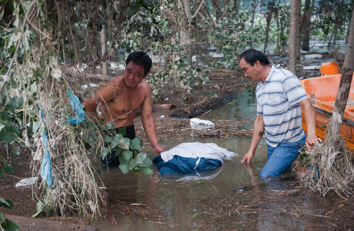 77 người chết là con số cao kỷ lục trong trận lụt lội tại thủ đô Bắc Kinh, Trung Quốc hôm 21/7 do mưa lớn kéo dài. 2 người đàn ông kéo xác người thân bị dạt trong lùm cây. 77 người chết là con số cao kỷ lục trong trận lụt lội tại thủ đô Bắc Kinh, Trung Quốc hôm 21/7 do mưa lớn kéo dài. 2 người đàn ông kéo xác người thân bị dạt trong lùm cây.