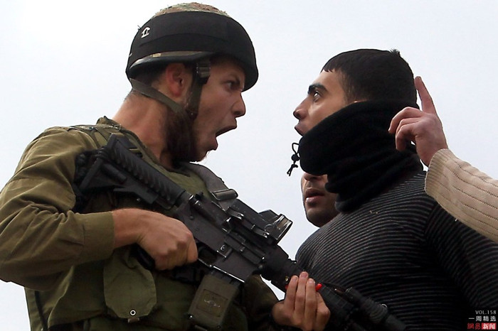 Ngày 17 Tháng 12, một cư dân Tây Bắc Palestine đối đầu với một binh sĩ Israel Ngày 17 Tháng 12, một cư dân Tây Bắc Palestine đối đầu với một binh sĩ Israel