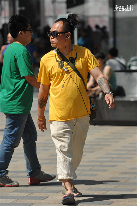 Tay xăm trổ, tóc búi ngược, tai đeo headphone Tay xăm trổ, tóc búi ngược, tai đeo headphone