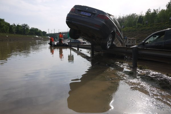 Dòng nước cuốn xe hơi nằm vắt ngang taluy