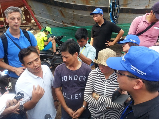Thuyền trưởng Đặng Văn Nhân (áo trắng bên trái) đang kể lại quá trình bị tàu Trung Quốc đâm chìm và anh em thoát chết một cách kỳ diệu trên biển. Ảnh H.Q
