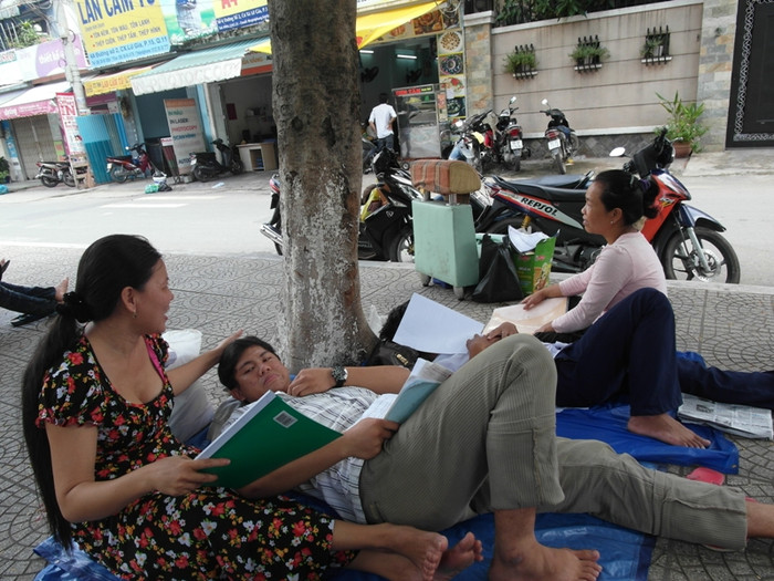 Trần Ngọc Gia Hoài đang thoải mái nằm dưới tán cây bên vệ đường ôn môn Lý. Thí sinh này được mẹ ngồi quạt cho mát. Hoài cho biết: “Em làm bài môn toán được khoảng 60%. Câu giá trị lớn nhất, nhỏ nhất khó quá trời, em bỏ luôn”. (Xem đáp án môn Vật lí - Xem đáp án môn Toán)