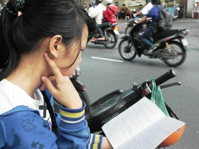 Ngồi bên vệ đường cạnh điểm thi Trường PTTH Lê Quý Đôn, thí sinh Huỳnh Thị Thanh Hoa quên mất xe cộ qua lại ồn ào, tập trung vào các công thức Hoá. Hoa cho biết bài thi môn Lý, Toán thấp điểm hôm qua đã làm em không tự tin cho môn Hoá hôm nay. Thí sinh này thi vào trường ĐH Sài Gòn. Xem đáp án môn Vật lí - Xem đáp án môn Toán - Xem đáp án môn Hóa