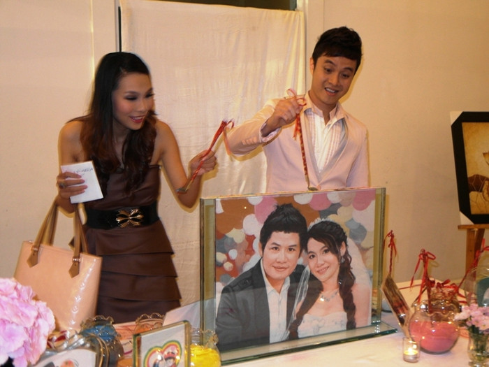 Cặp đôi ca sĩ Nhật Tinh Anh – Khánh Ngọc đã từng đưa ca khúc Vầng trăng khóc của chú rể thành ca khúc “hit” đang múc cát hạnh phúc đổ vào bức tranh cát, chúc mừng đôi uyên ương.