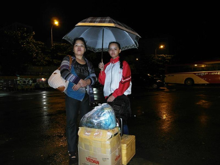 Chị Nguyễn Thị Kim Nguyệt và con gái là Lê Thị Hồng Đào vừa trải qua chưyến hành trình từ Đắklắk đến TP.HCM. Hai mẹ con đang đứng dưới mưa ngay tại bến xe, chờ người thân đến đón. Đợt 2 kỳ thi tuyển sinh Đại học, Hồng Đào chọn khối B, thi vào trường Đại Học Công Nghiệp. Hai mẹ con đứng dưới mưa rất lâu… Ảnh chụp tại bến xe Miền Đông, lúc 20 giờ. Xem đáp án môn Vật lí - Xem đáp án môn Toán - Xem đáp án môn Hóa - Xem đáp án môn Ngoại ngữ Khối A1